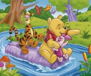 Puzzle de Winnie The Pooh y sus amigos Tigger y Piglet sentados sobre un tronco bajando por el rio