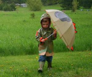 Puzzle de Niño con su paraguas y su chaqueta impermeable bajo la lluvia de primavera