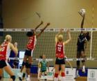 Voleibol o vóley - Jugadora rematando el balón ante el intento de bloqueo del equipo contrario