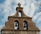 Campanario de una iglesia con dos campanas y una cruz en todo lo alto