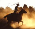 Cowboy o vaquero cabalgando con el lazo