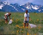 Dos chicas cazando mariposas por el campo