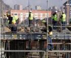 Vista general de una casa en construcción con diferentes operarios trabajando