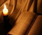 La Biblia y una vela encendida sobre el altar