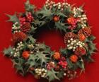 Corona de Navidad formada por hojas de acebo y frutas variadas