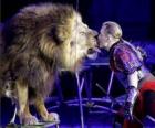 León junto a su domador con un látigo en las manos