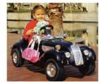 Niña en un coche clasico de juguete