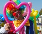 Payaso con un globo de color rosa en forma de corazón