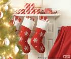 Calcetines navideños decorados y colgados en la pared de la chimenea