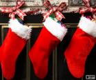 Calcetines navideños decorados y colgados en la pared de la chimenea
