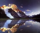 Un lago con el reflejo de la motaña en sus aguas