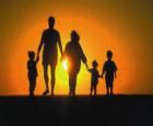 Familia, padre, madre y tre hijos paseando al atardecer