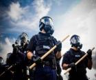 Agentes de policías antidisturbios con la porra en la mano