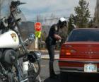 Agente de policía motorizada con su motocicleta y poniendo una multa a un conductor