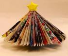 Árbol navideño hecho con hojas de revistas y una estrella amarilla en la punta