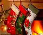 Calcetines navideños decorados y colgados en la pared de la chimenea