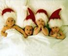 Cuatro bebés con el gorro de Papá Noel