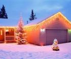 Casa decorada con adornos navideños y dos arboles de navidad en el jardin