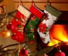 Calcetines navideños decorados y colgados en la pared de la chimenea
