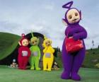Po, Laa-Laa, Dipsy y Tinky-Winky con su bolso rojo en frente de su casa