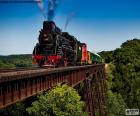 Tren de vapor pasando por encima de un puente de hierro