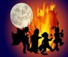 niños disfrazados bailando junto al fuego