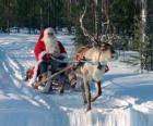 Papá Noel en su trineo con un reno sobre la nieve