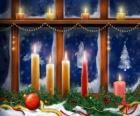 Velas de Navideñas encendidas delante de una ventana