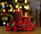 Velas encendidas como centro de mesa adornadas con flores de Navidad