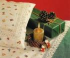Vela de Navidad encendida junto con otros adornos navideños