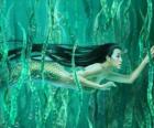 Sirena nadando entre las algas