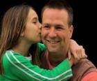Niña felicitando a su padre con un abrazo y un gran beso
