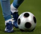 Jugador de futbol conduciendo el balón