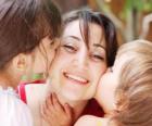 Mamá o madre recibiendo besos de sus hijos