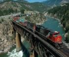 Tren de mercancias pasando por encima de un puente