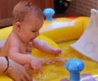 Niña bañandose en una pequeña piscina inflable