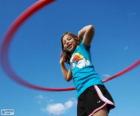 Niña jugando con el hula-hula, haciendo girar el hula hoop con la cintura