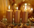 Tres velas navideñas doradas
