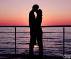 Pareja de enamorados besándose junto al mar