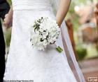 La novia con un precioso ramo blanco en la mano