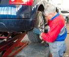 Mecánico de coches trabajando en una rueda en su taller