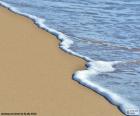 Una playa de arena fina y suave oleaje