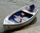 Un pequeño bote blanco de madera con motor