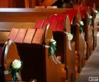 Los bancos de la iglesia adornados para una boda con flores