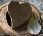 Corazón tallado en madera y un pétalo blanco