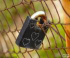 Candado cerrado en una malla metálica con cinco corazones