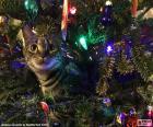 Un gato curioso entre los adornos colgados del árbol de Navidad