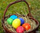 Cesto con seis huevos de Pascua, cada uno pintado de un color diferente