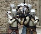 Cuatro caballeros llevan a un compañero herido durante la batalla
