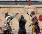Tres caballeros luchando con espadas en un torneo